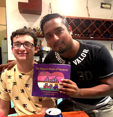 2020 JOHN WRITES AND ILLUSTRATES THE MAGICAL HEART OF HANDOM, PICTURE OF JOHN AND PEDRO FROM MEXICO, ADDING OUR 7TH COUNTRY. 